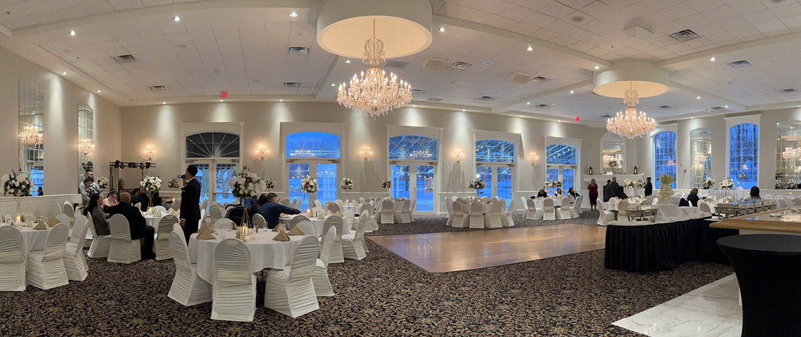Banquet hall with gorgeous chandeliers and a large dance floor at a winter event