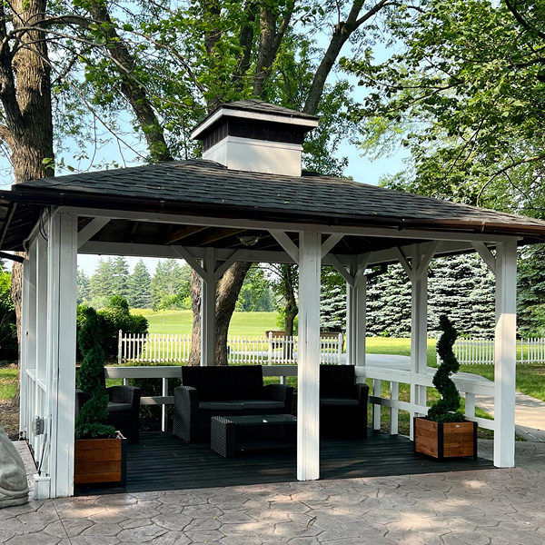 Gazebo with patio furniture and greenery