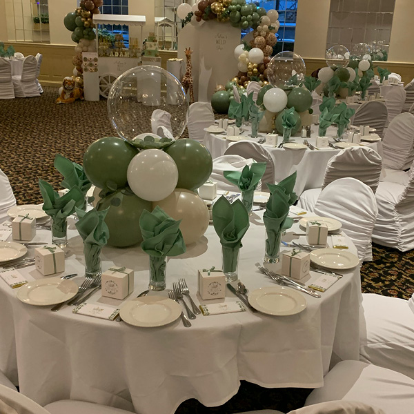 Banquet hall decorated in green and white balloons for a birthday party