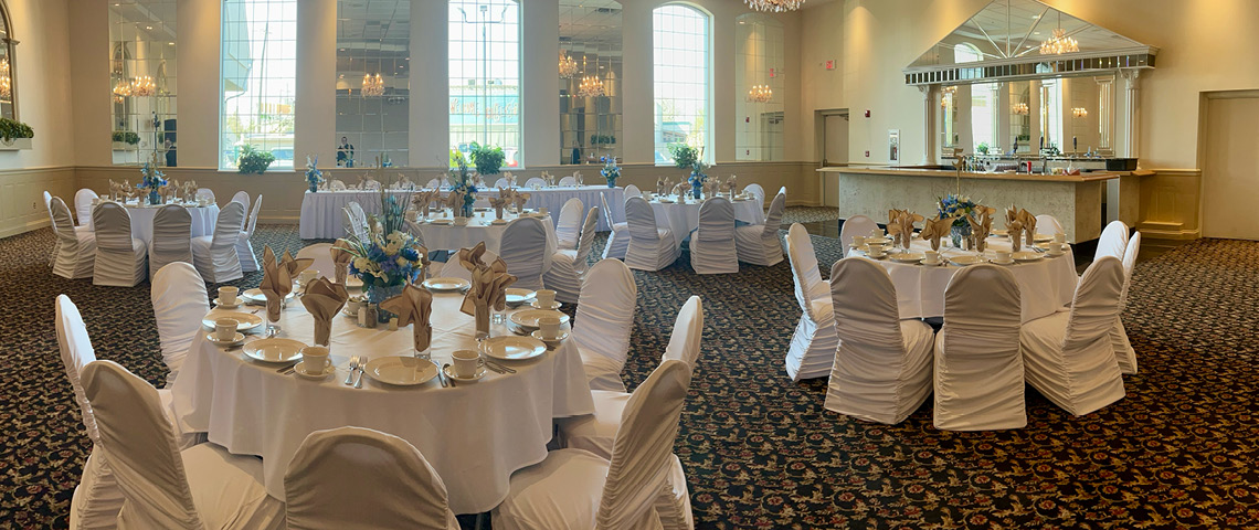 Event space with decorated tables and chairs, large windows and a bar