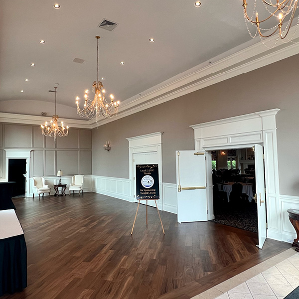 Gray and white foyer with chandeliers and hardwood floors