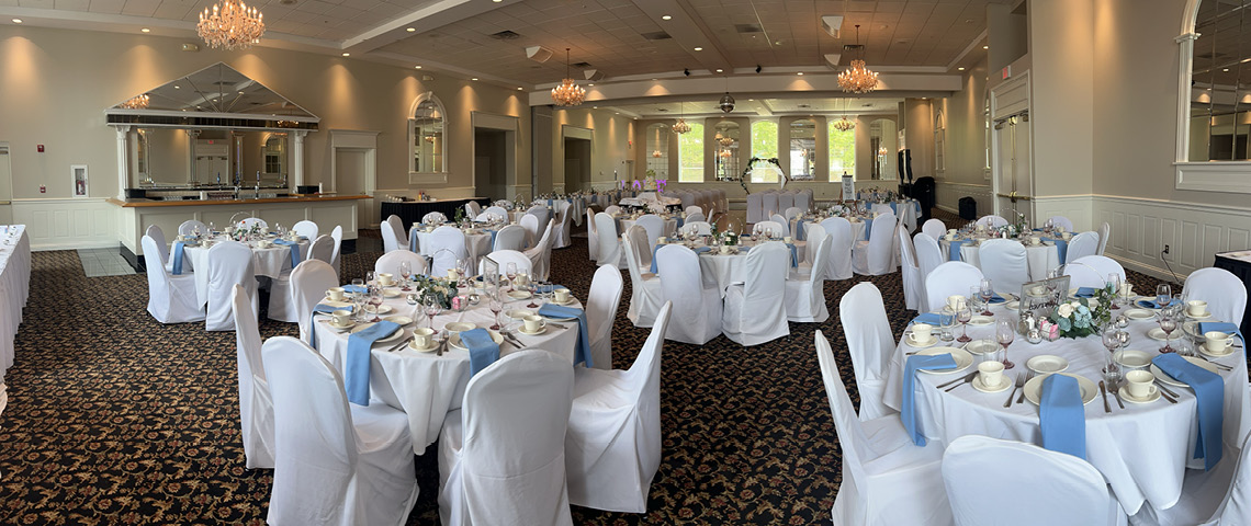 Ballroom decorated for a wedding with white and blue linens