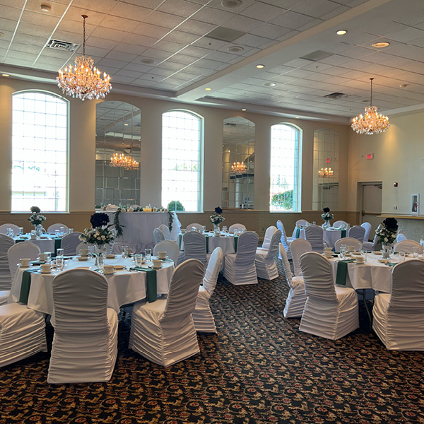 Tall centerpieces on tables with white and green linens