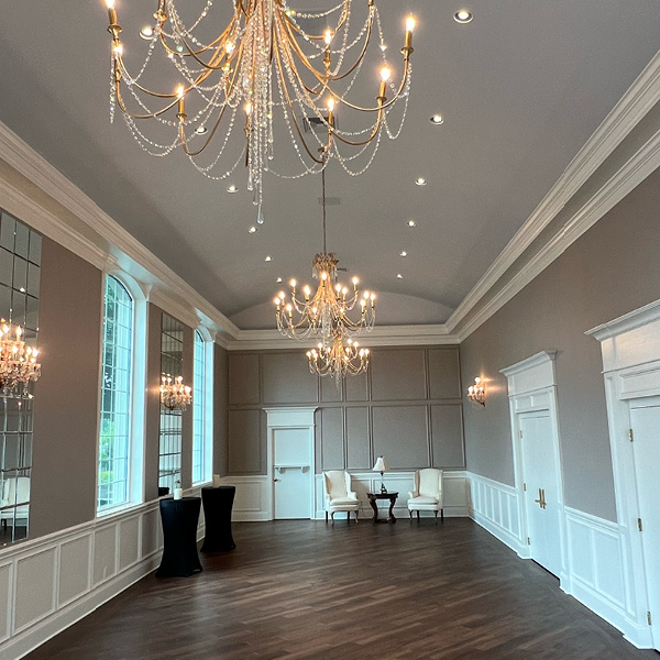 Beautifully renovated foyer with wainscoting and elegant chandeliers