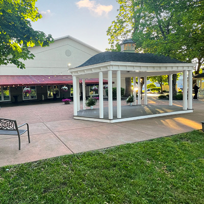 Outdoor patio space with an awning, gazebo, and lawn space