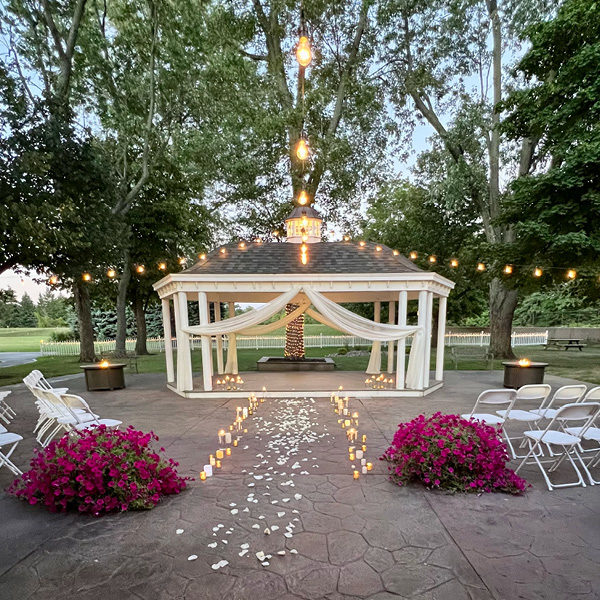 Gazebo decorated for a wedding with patio string lights and flowers